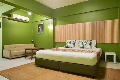 a bedroom with a large bed and a chair at XX GO INN The Grand Palace - โกอินน์ พระบรมมหาราชวัง MRT สามยอด in Bangkok