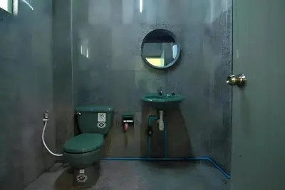 a bathroom with a green toilet and a sink at XX GO INN The Grand Palace - โกอินน์ พระบรมมหาราชวัง MRT สามยอด in Bangkok