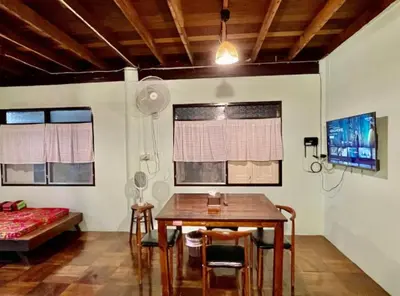 a room with a table and chairs and a bed at Lamduan house whole House - 3BR - Experience temple and canal life in Bangkok