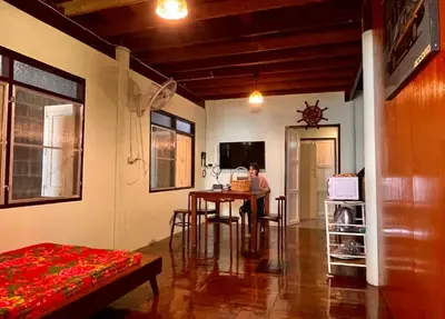 a person sitting at a table in a room at Lamduan house whole House - 3BR - Experience temple and canal life in Bangkok