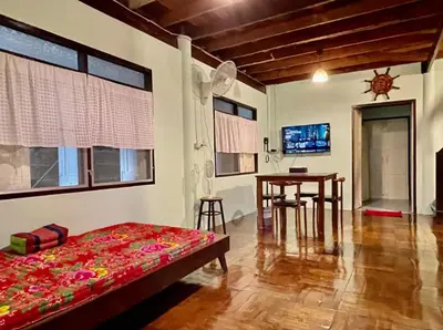 a bedroom with a bed and a table in a room at Lamduan house whole House - 3BR - Experience temple and canal life in Bangkok