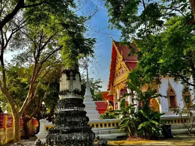 a temple in front of a red and white building at Lamduan house whole House - 3BR - Experience temple and canal life in Bangkok