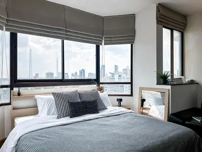 a bedroom with a large bed with a large window at Luxurious 2BR Ultra Fast Wifi Phrom Phong in Bangkok
