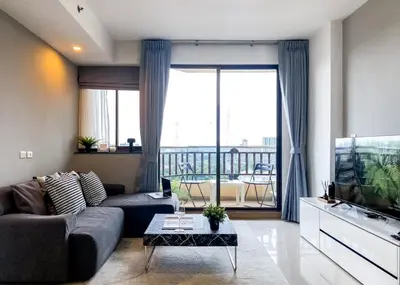 a living room with a couch and a large window at Luxurious 2BR Ultra Fast Wifi Phrom Phong in Bangkok
