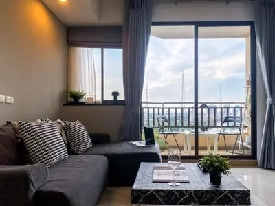a living room with a couch and a large window at Luxurious 2BR Ultra Fast Wifi Phrom Phong in Bangkok