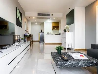 a living room with a table and a kitchen at Luxurious 2BR Ultra Fast Wifi Phrom Phong in Bangkok