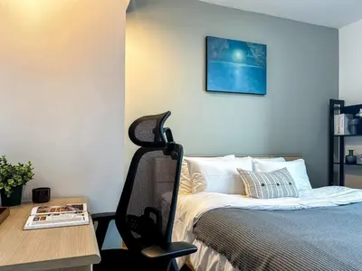 a bedroom with a bed and a desk with a chair at Luxurious 2BR Ultra Fast Wifi Phrom Phong in Bangkok