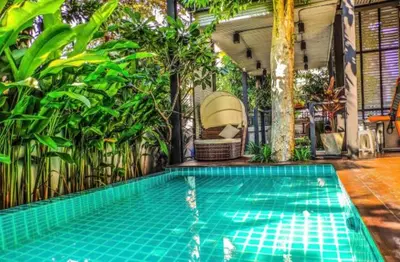 a swimming pool in a house with plants at Garden and pool Villa bangkok in Bang O