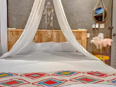 a bedroom with a bed with a mosquito net at Garden and pool Villa bangkok in Bang O