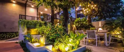 a patio with a table and chairs and plants at Garden and pool Villa bangkok in Bang O