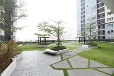 a courtyard with a park with trees in a building at Prime Near Sathorn Sukhumvit Central in Chong Nonsi