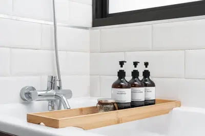 a shelf with three bottles of wine sitting on a sink at King suite with kitchen-Short walk to Park,BTS,Mall in Khlong Toei
