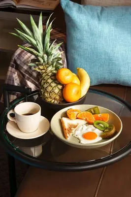 a coffee table with a plate of eggs and fruit at King suite with kitchen-Short walk to Park,BTS,Mall in Khlong Toei