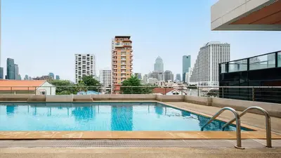 a swimming pool on top of a building with a city skyline at King suite with kitchen-Short walk to Park,BTS,Mall in Khlong Toei