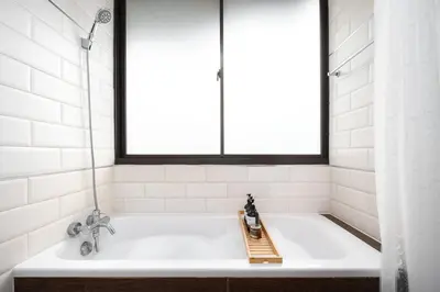 a bathtub in a bathroom with a window at King suite with kitchen-Short walk to Park,BTS,Mall in Khlong Toei