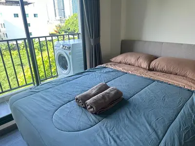 a bed with two towels on it with a balcony at Brand new Condo near ICON SIAM in Bangkok