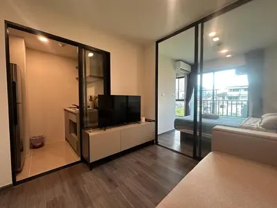 a living room with a flat screen tv and a mirror at Brand new Condo near ICON SIAM in Bangkok