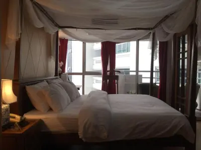 a bedroom with a canopy bed with a window at 1br with Pool Gym near BTS Phrom Phong in Khlong Toei