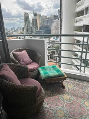 a balcony with two chairs and a table on a building at 1br with Pool Gym near BTS Phrom Phong in Khlong Toei