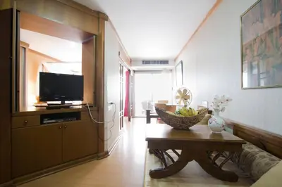 a living room with a television and a table at 1br with Pool Gym near BTS Phrom Phong in Khlong Toei