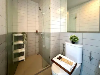a bathroom with a toilet and a glass shower at Tranquil Apt 2 BR - Ultra Fast Wifi - BTS On Nut in Bangkok