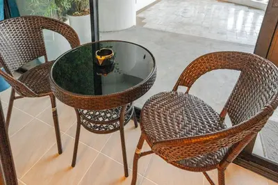 a glass table with three chairs and a bowl on it at Bangrak HANGOVER 2 Central River Station in Bangkok