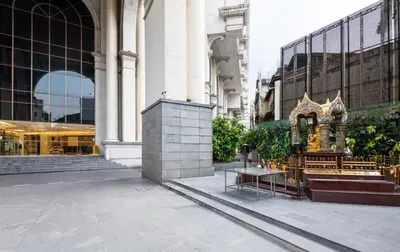 a building with a church in the middle of a street at Bangrak HANGOVER 2 Central River Station in Bangkok