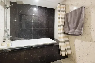 a bathroom with a shower and a bath tub at Bangrak HANGOVER 2 Central River Station in Bangkok