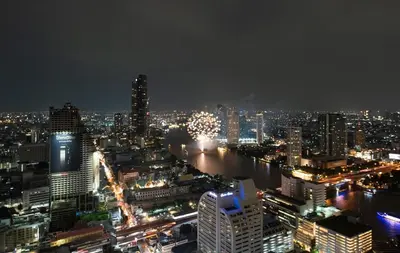 a city skyline at night with a river and buildings at Bangrak HANGOVER 2 Central River Station in Bangkok
