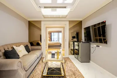 a living room with a couch and a tv at Bangrak HANGOVER 2 Central River Station in Bangkok