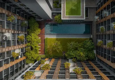 an overhead view of a building with a pool and plants at Luxury Resort vibes-5mins walk BTS Ekkamai in Bangkok