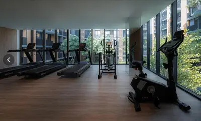 a gym with treadmills and machines in a building at Luxury Resort vibes-5mins walk BTS Ekkamai in Bangkok
