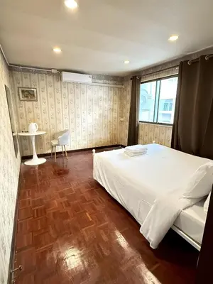a bedroom with a large white bed and a table at xx Stay On Sukhumvit Soi 11 BTS Nana - สเตย์ออน สุขุมวิท 11 รถไฟฟ้านานา in Makkasan