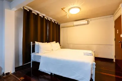 a bedroom with a white bed and a black curtain at xx Stay On Sukhumvit Soi 11 BTS Nana - สเตย์ออน สุขุมวิท 11 รถไฟฟ้านานา in Makkasan