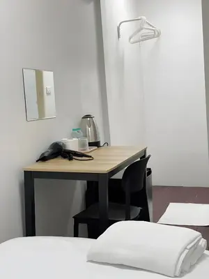 a desk in a room with a table with a kettle on it at xx GO INN Siriraj BKK โกอินน์ ศิริราช in Bangkok Noi
