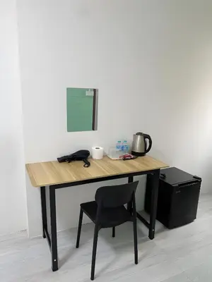 a wooden desk with a chair next to a wall at xx GO INN Siriraj BKK โกอินน์ ศิริราช in Bangkok Noi