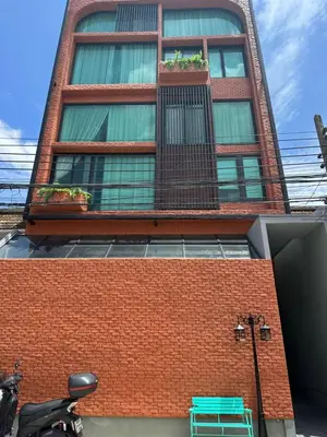 a red brick building with two windows and a green bench at Thai Loft \u6cf0\u95a3 in Bangkok