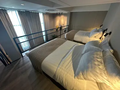 a hotel room with two beds and a balcony at Thai Loft \u6cf0\u95a3 in Bangkok