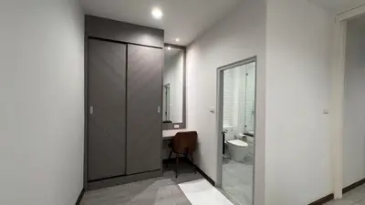 a bathroom with a sliding door with a sink and a toilet at The Kite Hotel Bangkok in Bangkok