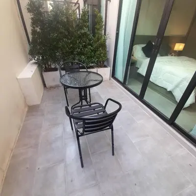 a table and chairs on a balcony with a bed at The Kite Hotel Bangkok in Bangkok