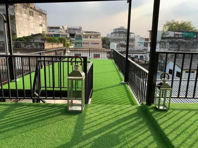 two lanterns on a balcony with green grass at The Kite Hotel Bangkok in Bangkok
