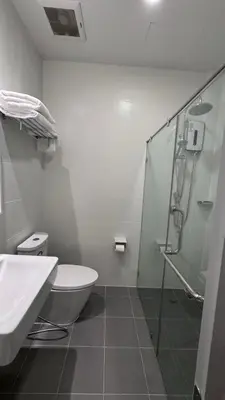 a bathroom with a shower and a toilet and a sink at The Kite Hotel Bangkok in Bangkok