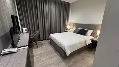 a hotel room with a bed and a television at The Kite Hotel Bangkok in Bangkok