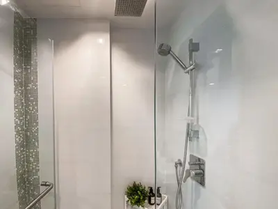 a shower with a glass door in a bathroom at Modern High-Rise 1BR - Ultra Fast Wifi - Sathorn in Bangkok