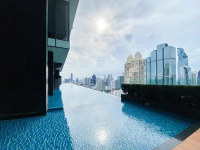 a swimming pool on the roof of a building with a city skyline at Modern High-Rise 1BR - Ultra Fast Wifi - Sathorn in Bangkok