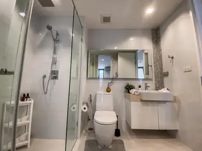 a bathroom with a shower and a toilet and a sink at Modern High-Rise 1BR - Ultra Fast Wifi - Sathorn in Bangkok