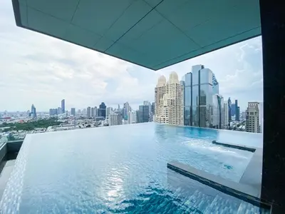 a swimming pool on top of a building with a city at Modern High-Rise 1BR - Ultra Fast Wifi - Sathorn in Bangkok