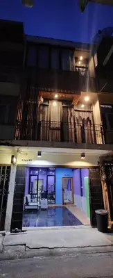 a building with a pool in front of it at night at Ber Ben House in Bang Su