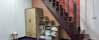 a staircase with a shelving unit next to a brick wall at Ber Ben House in Bang Su