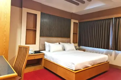a bedroom with a bed and a desk in it at The Rich Hotel Rama 5 in Ban Bang Phai